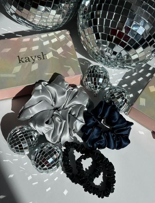 100% mulberry silk scrunchies next to a gift box. Shiny, luxurious and soft to touch.