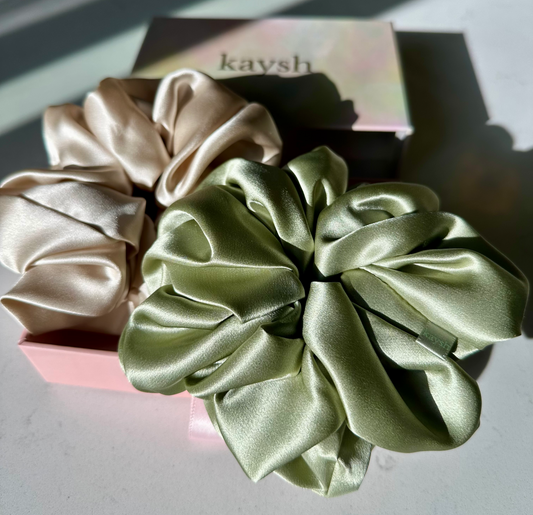 100% mulberry silk scrunchies next to a gift box. Shiny, luxurious and soft to touch. 